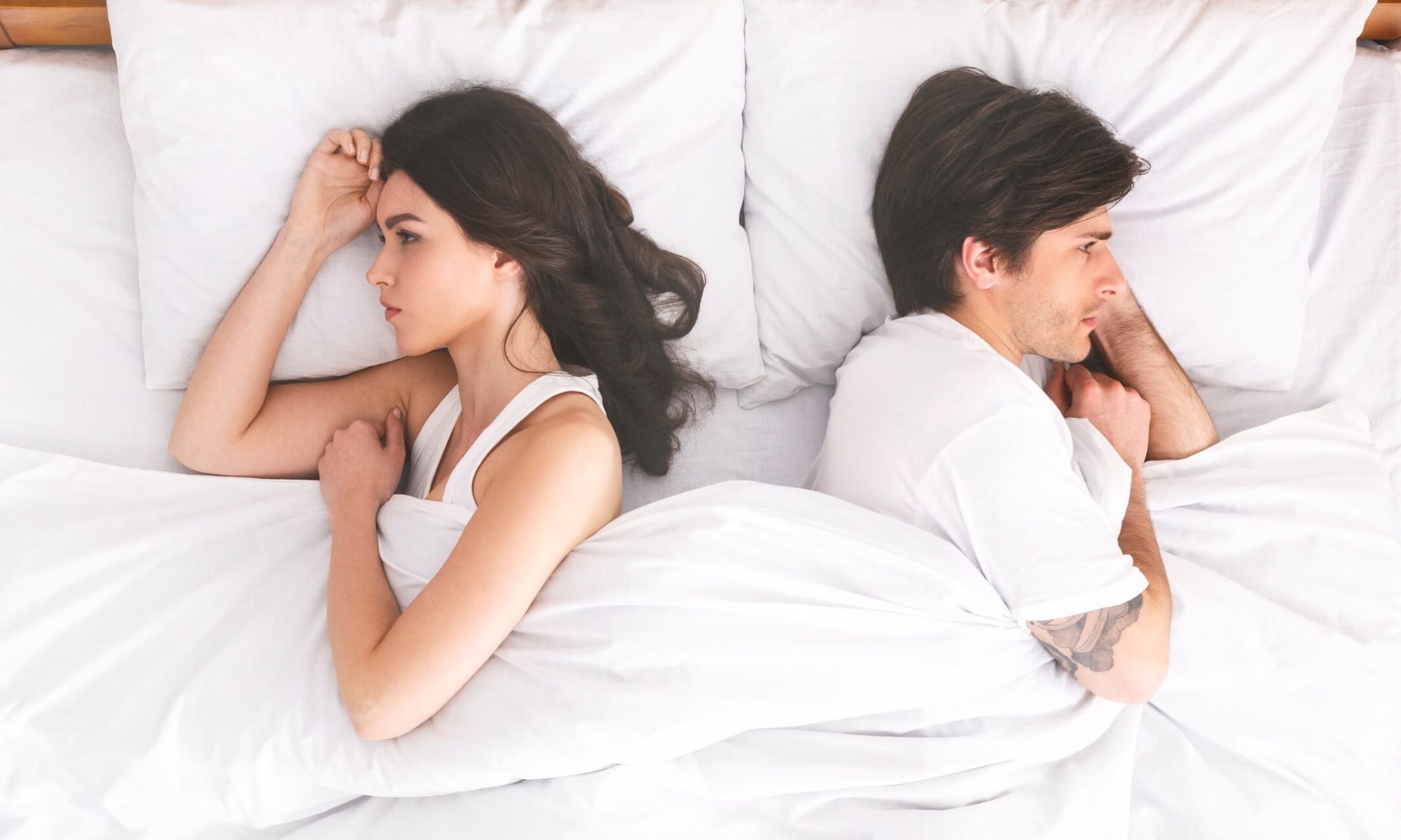 Couple in bed feeling disconnected and upset with each other